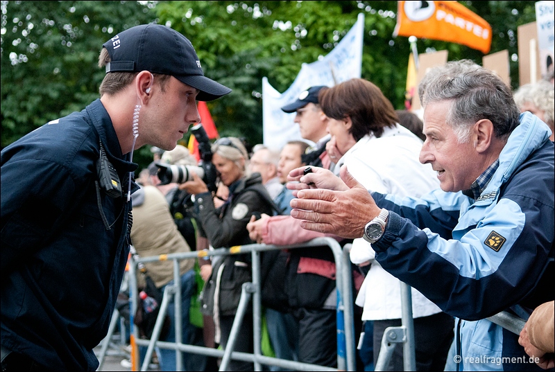 Ein Demonstrant diskutiert an einer Polizeiabsperrung nahe des Baugeländes mit einem Polizisten