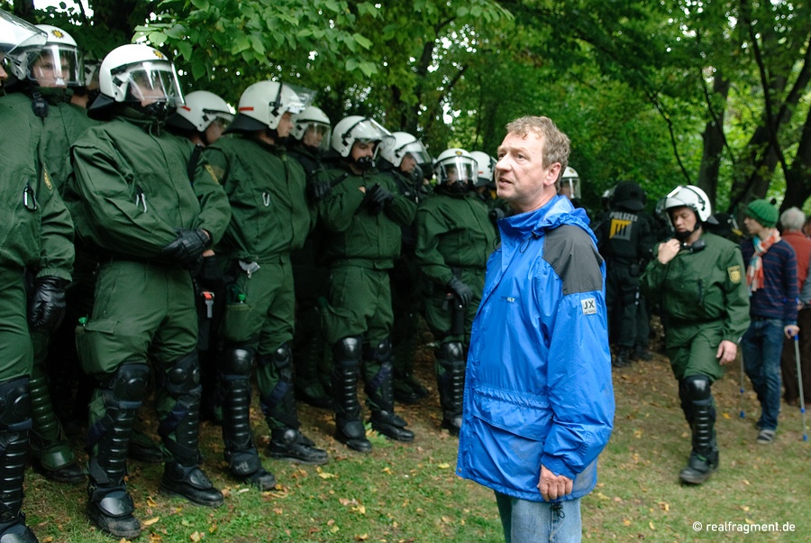 A protester is standing opposite to a police line