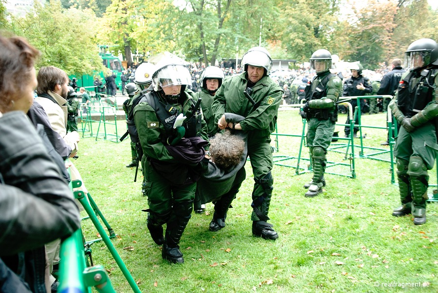 Eine Demonstratntin wird von Polizeikräften weggetragen