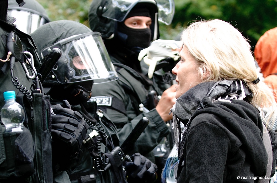 Eine Frau diskutiert mit Spezialkräften der Polizei