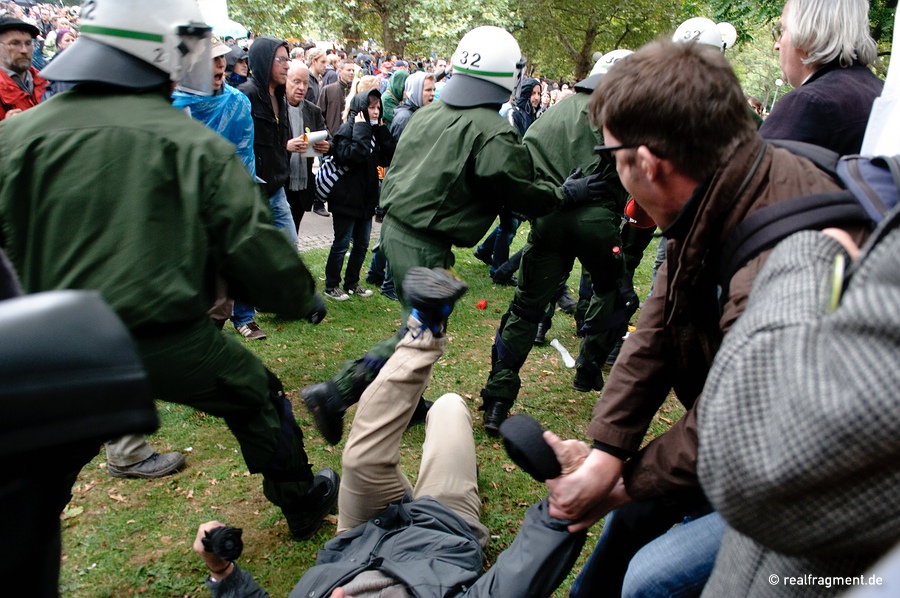 A group of policemen cleave through the crowd