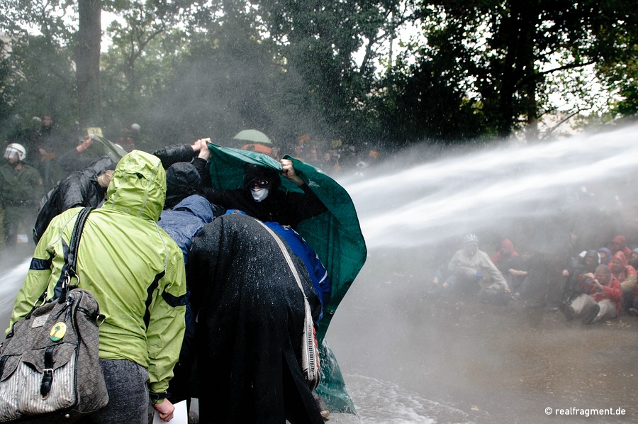 Demonstrators are trying to protect themselves against a water-cannon