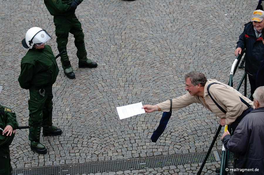 A demonstrator tries to hand over a flyer to a police man